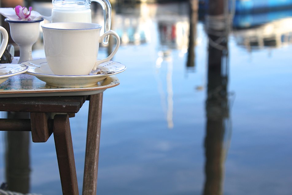 Kaffekopp vid bryggan med havet intill.