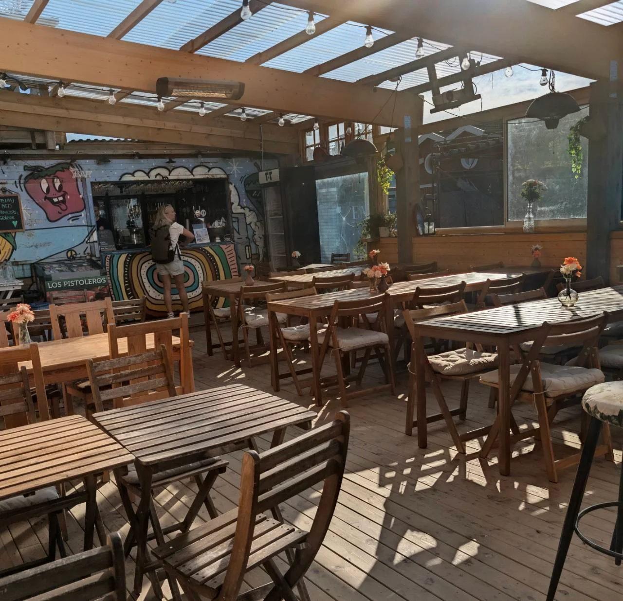 Restaurangens bord och färgglada bar i dagsljus på Brännö Varv.